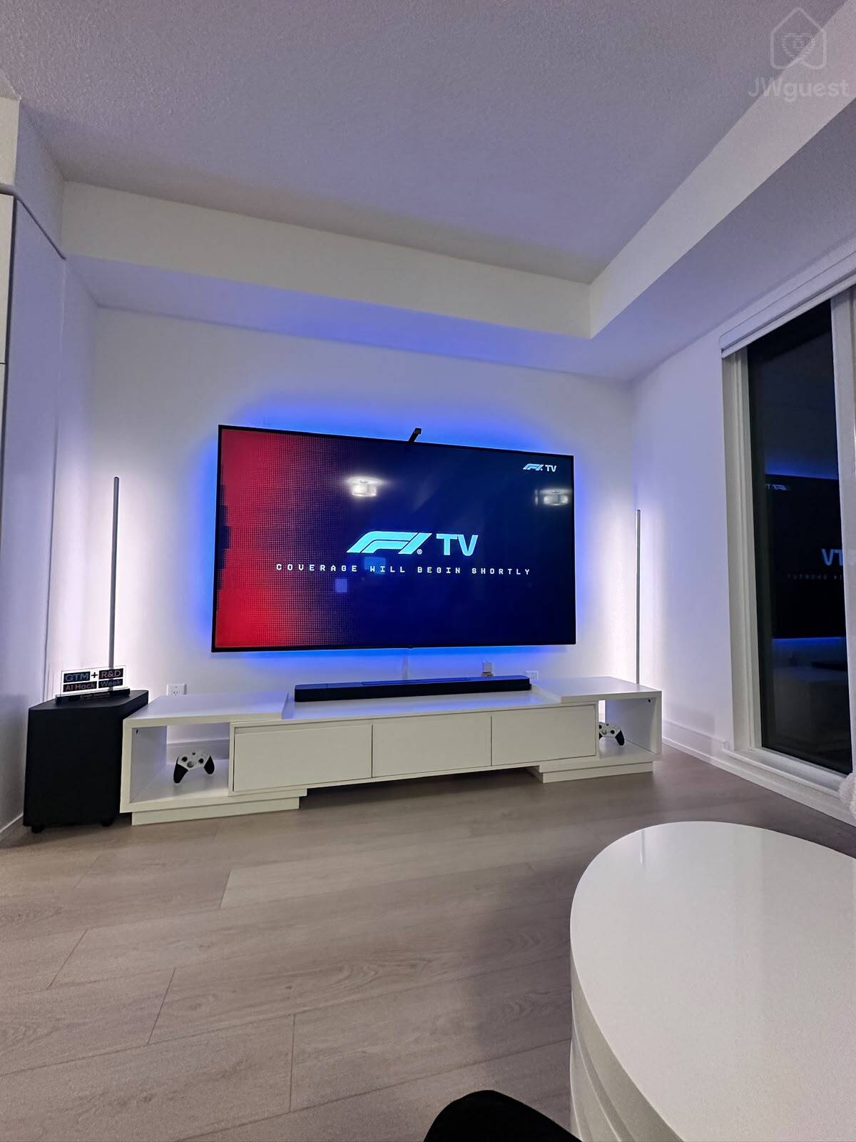 90'' wall-mounted TV with a comfortable media and lounge area — Downtown Toronto Stay | Steps from CN Tower & King West, Toronto, Ontario