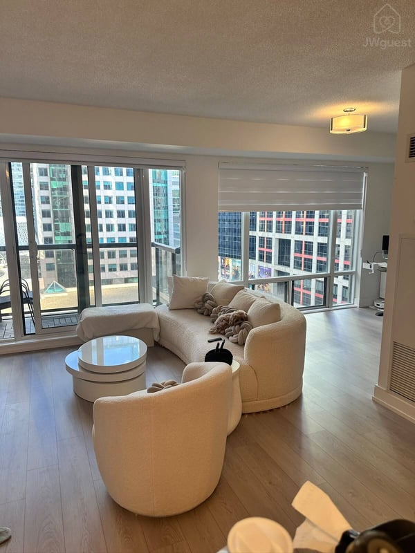 Spacious living room surrounded by large windows and natural light — Downtown Toronto Stay | Steps from CN Tower & King West, Toronto, Ontario