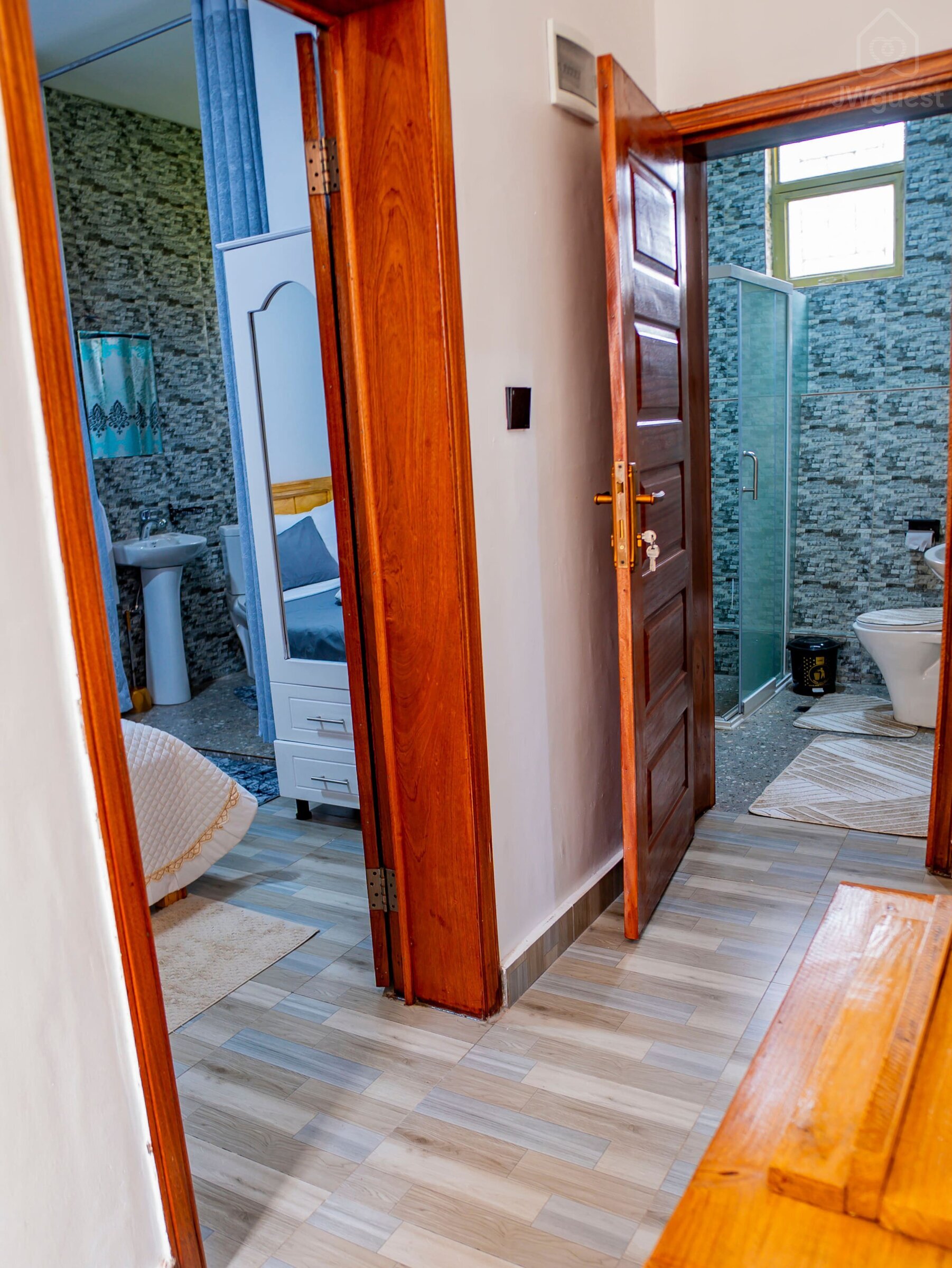 External view of Bedroom 1 and Bathroom 2 from the corridor. — Cozy 2-Bedroom Haven Near KGL Airport - Valley View, Kigali, Kigali City