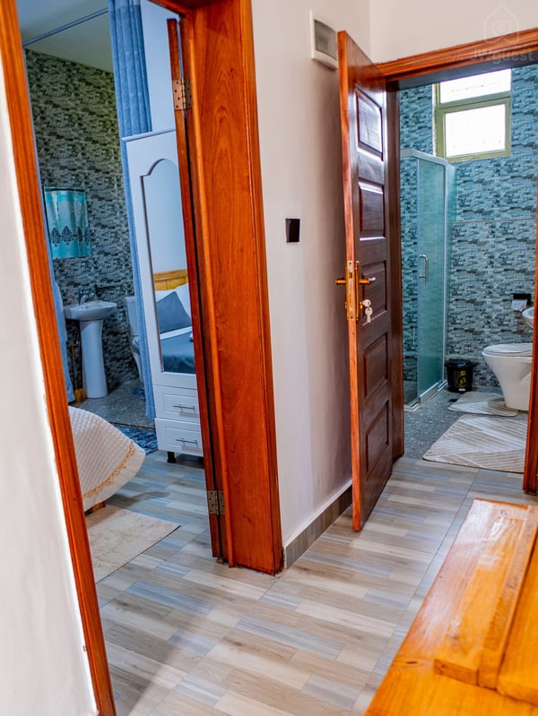External view of Bedroom 1 and Bathroom 2 from the corridor. — Cozy 2-Bedroom Haven Near KGL Airport - Valley View, Kigali, Kigali City