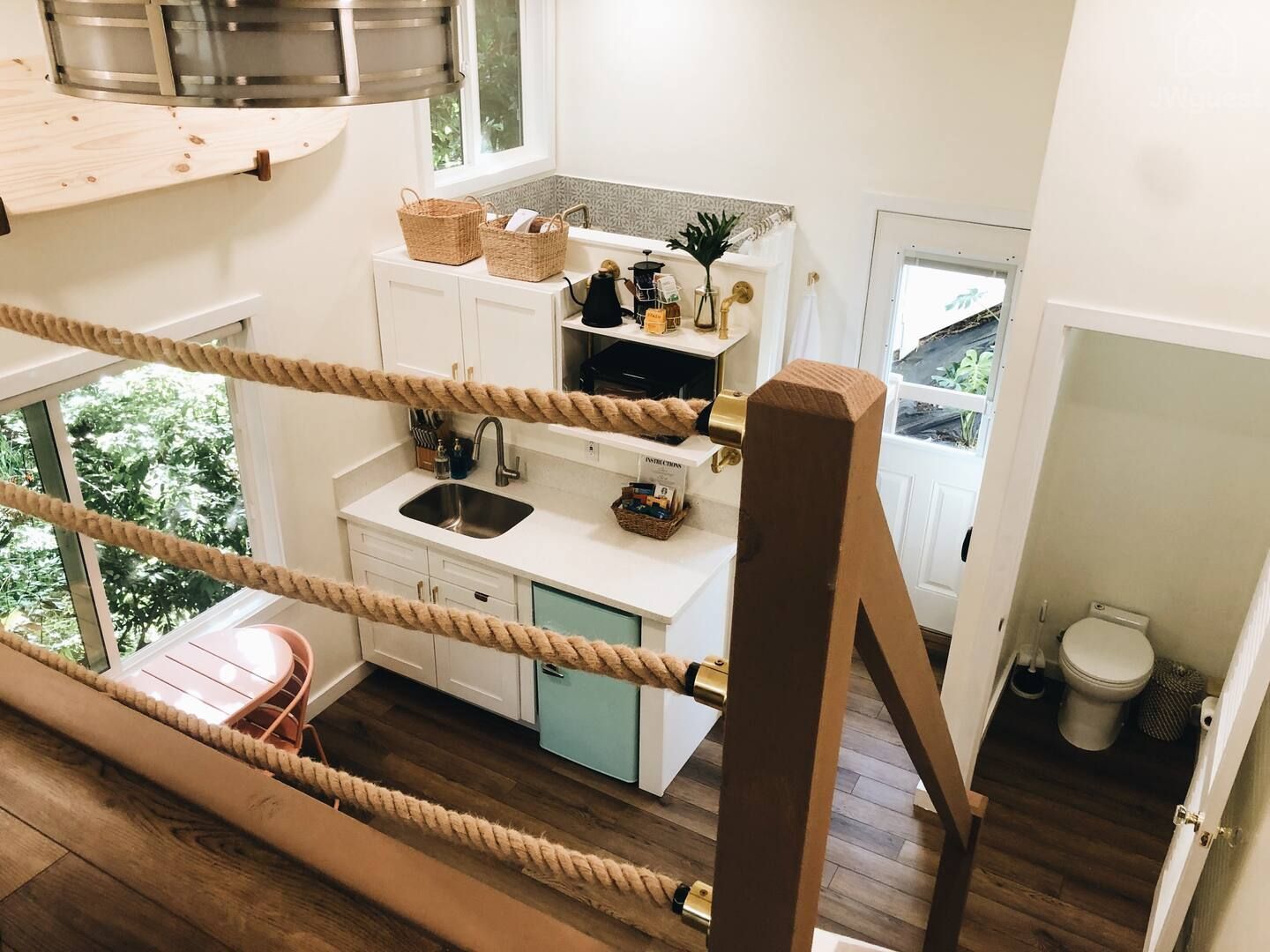 A view from the bedroom loft looking down onto the open, airy treehouse apartment — Elevated Jungle Treehouse with Loft BR, Mililani, Hawaii