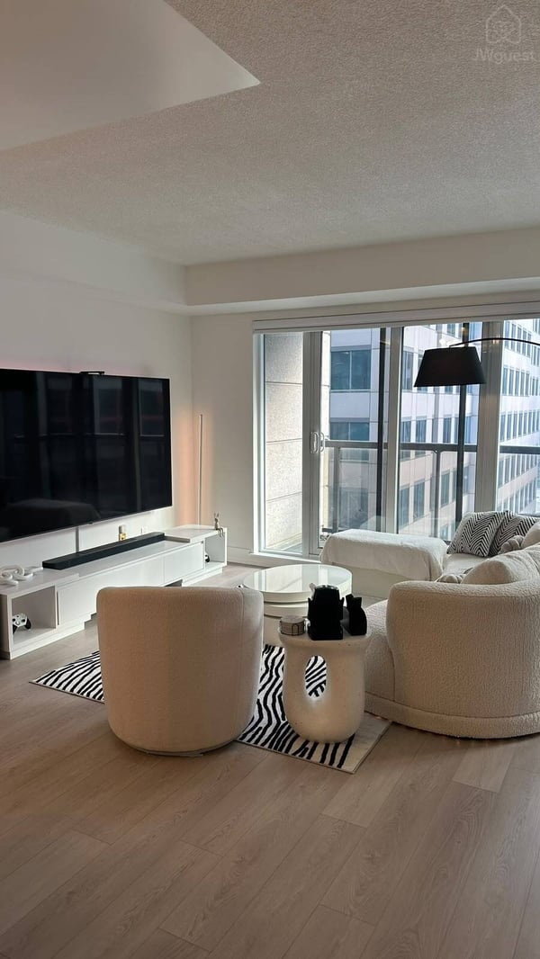 Bright modern living room with 90'' TV and floor-to-ceiling windows — Downtown Toronto Stay | Steps from CN Tower & King West, Toronto, Ontario