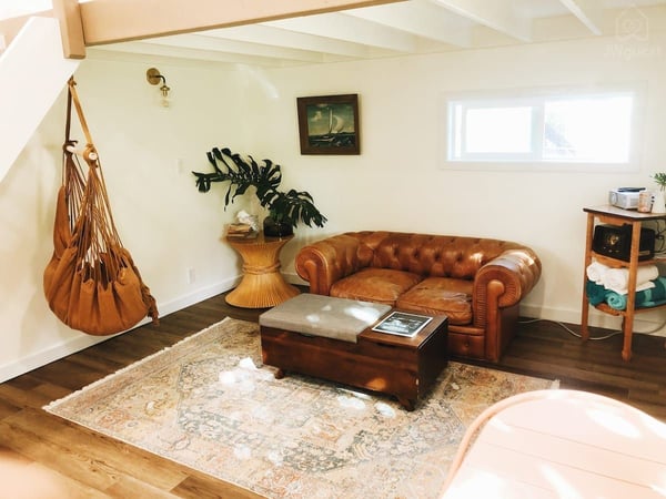 Relax on the sofa in the cozy living nook with its own little window out to the trees — Elevated Jungle Treehouse with Loft BR, Mililani, Hawaii