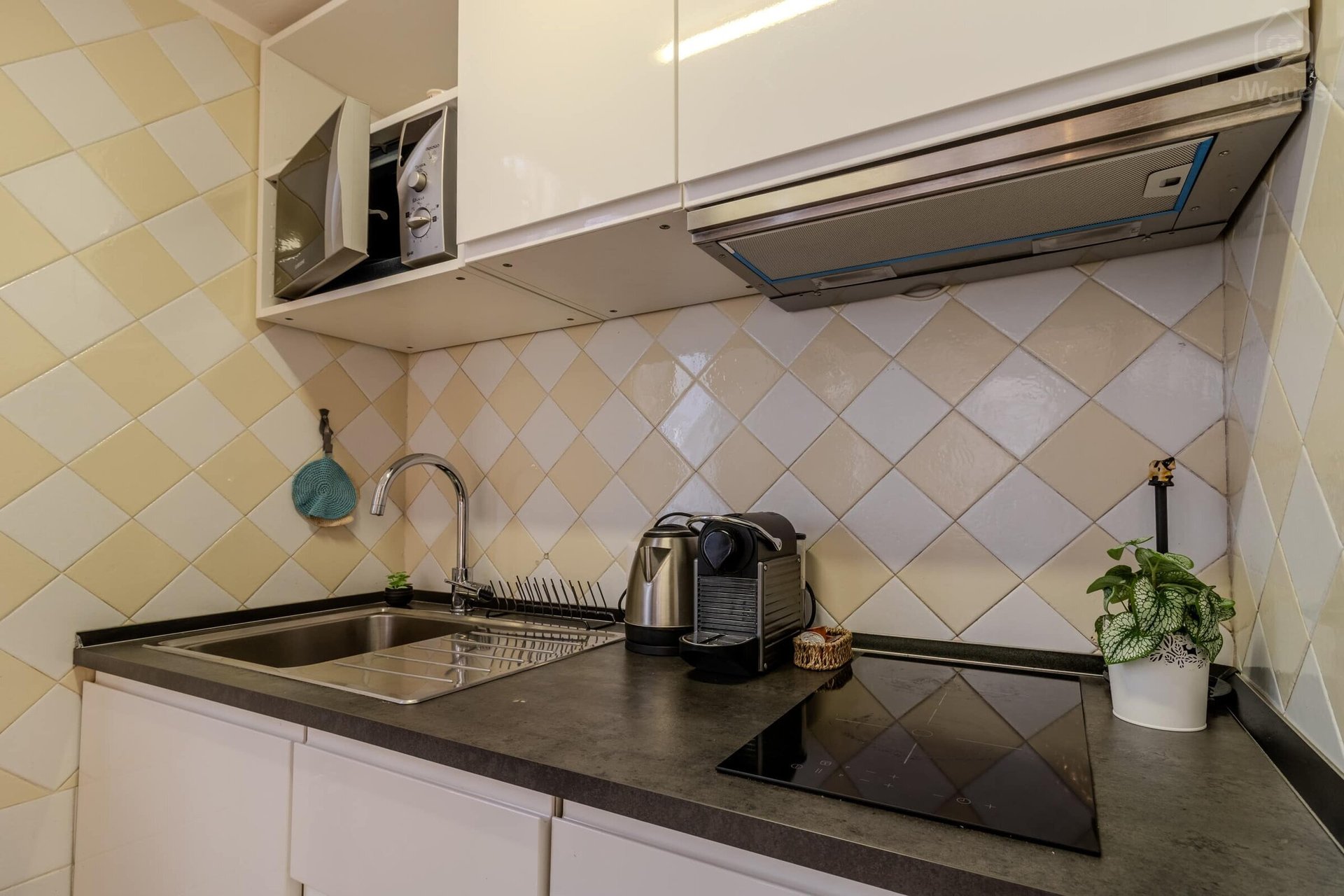 Cucina con fornelli a induzione, bollitore e macchinetta del caffè con cialde incluse