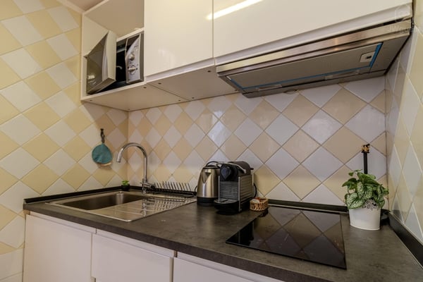 Cucina con fornelli a induzione, bollitore e macchinetta del caffè con cialde incluse