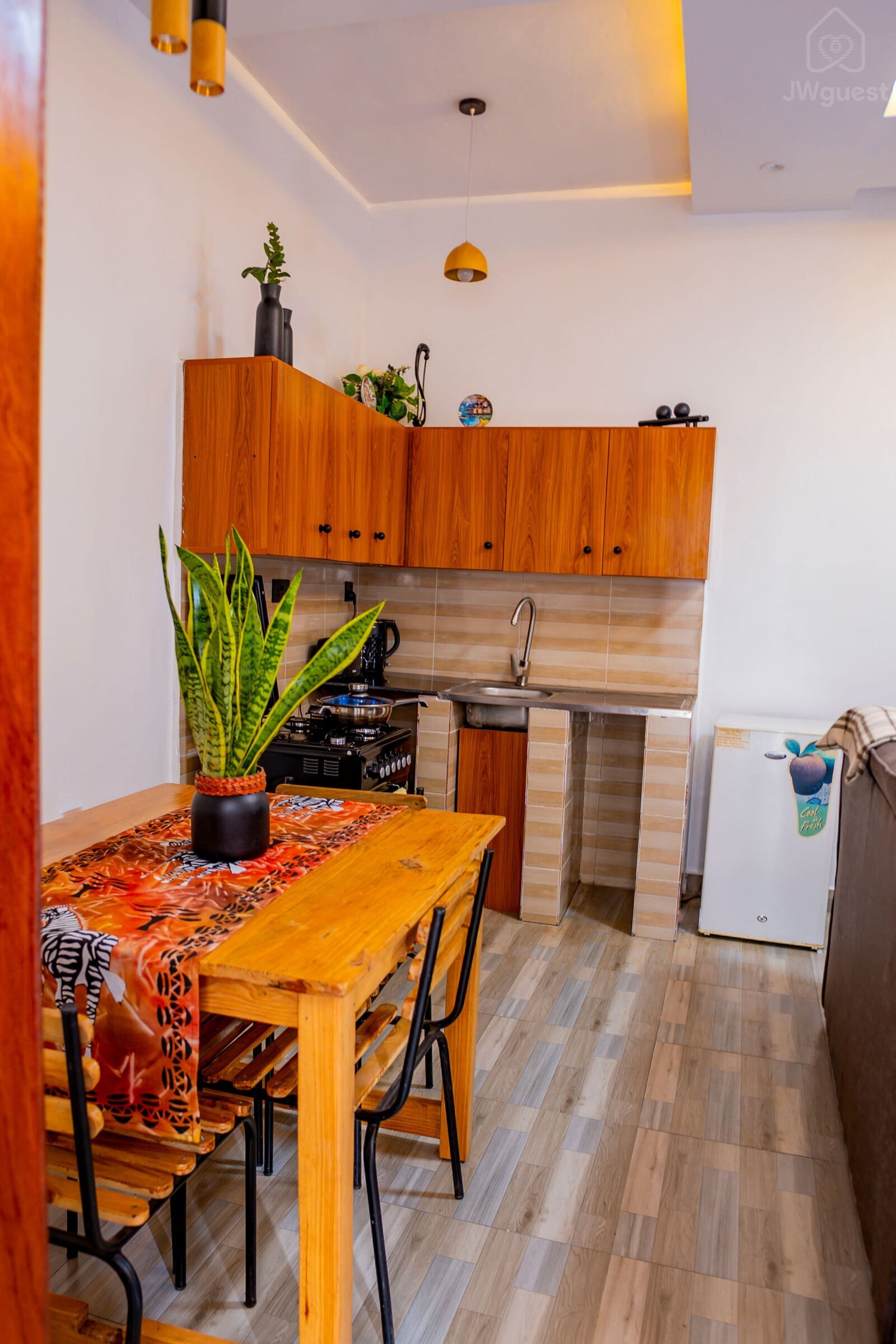 Open space - Sitting area & Kitchen Kitchen - furnished with a kettle, coffee maker, toaster, stove, fridge and sink… — Cozy 2-Bedroom Haven Near KGL Airport - Valley View, Kigali, Kigali City