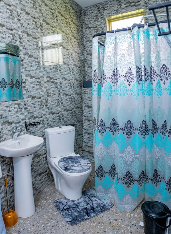 Bathroom 1 located in Bedroom 1 - ensuite Luminous and conveniently located in the room for your privacy and comfort. — Cozy 2-Bedroom Haven Near KGL Airport - Valley View, Kigali, Kigali City